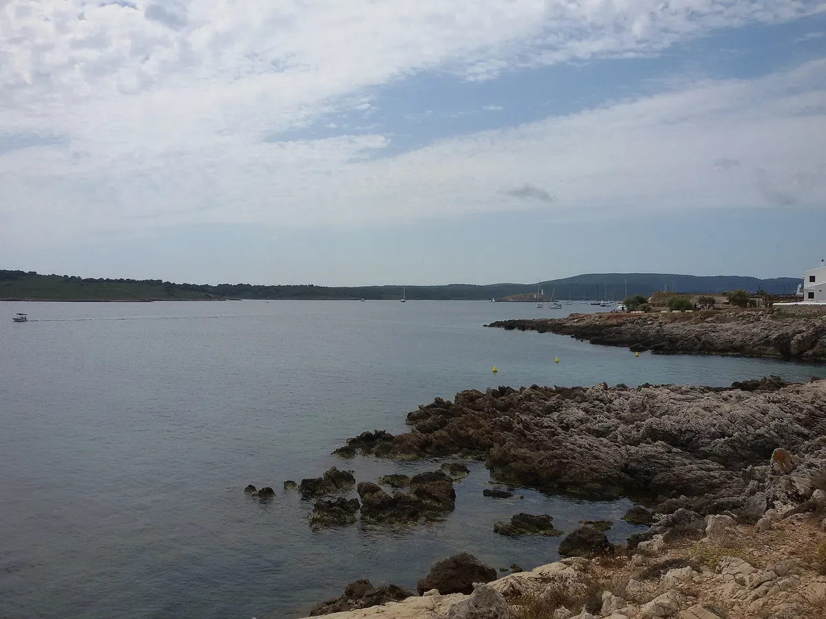 Calm shallow water in the Bahia de Fornells in northern Menorca where family catamaran trips run on gentle seas
